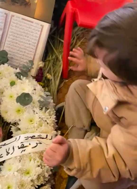 الطفل حسن إبن الشهيد السيد علي عاشور .. يتحدث مع والده فوق ضريحه المبارك عن عيد ميلاد أخته الصغيرة ن